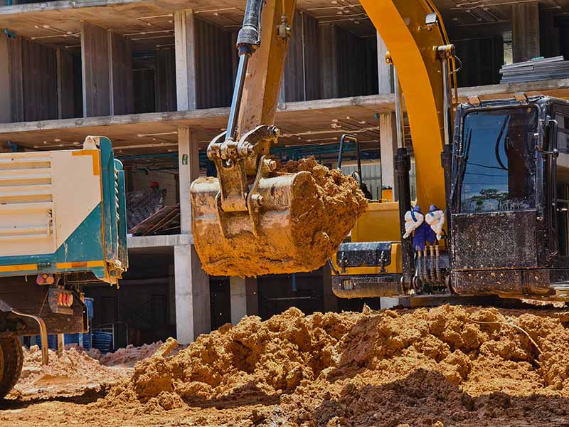 Excavator loads ground into a dump truck at a construction site scavi per edilizia a parma